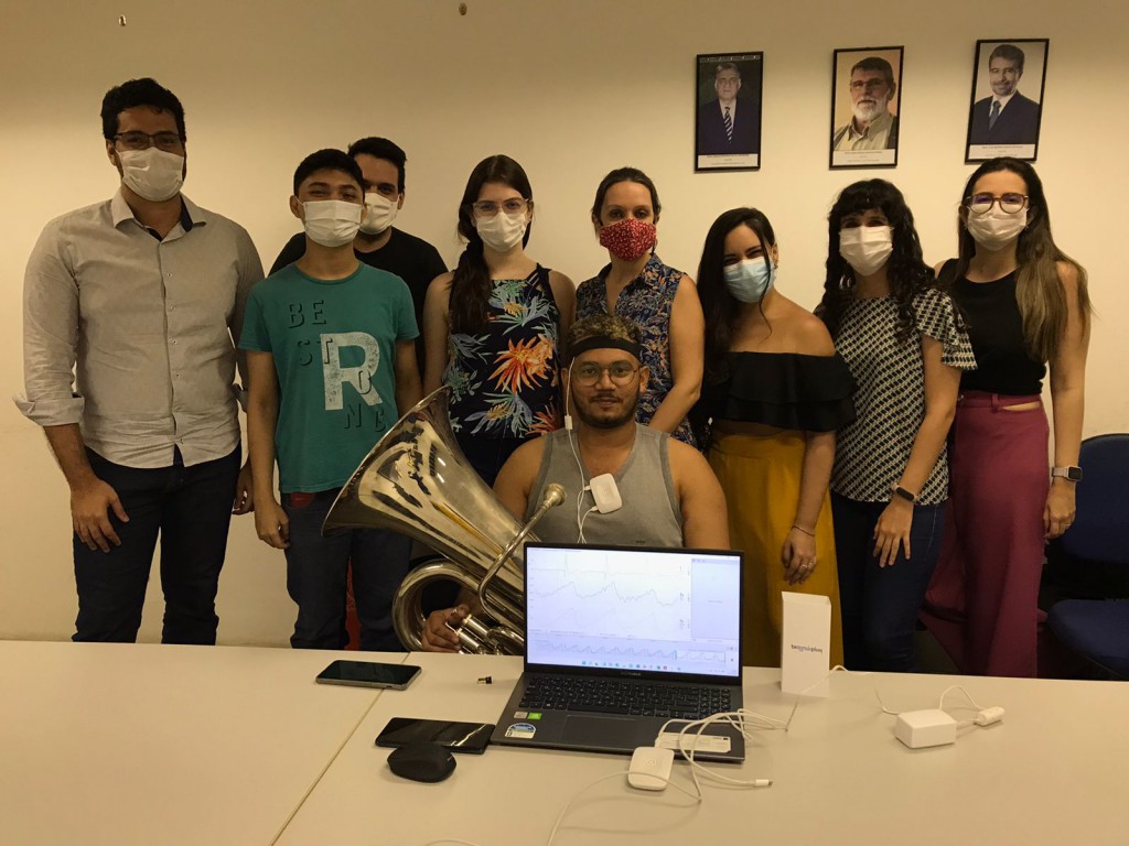 A equipe envolvida (a partir da esquerda): professor Alex Grangeiro, Rafael Mendes, Lucas Chaves, Ana Cecília Carvalho, professora Adeline Stervinou, Rebeca Paiva, Carolina Rossi, Professora Eva Cristino, e Henrique Pinheiro testando o aparelho tocando tuba.